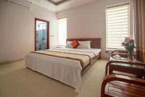 Biệt thự Sao Biển - SB118 FLC Sầm Sơn Resort في سام سون: غرفة نوم بسرير كبير وطاولة زجاجية