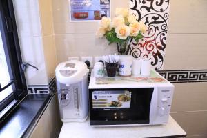 a microwave on a counter with a vase of flowers at European Hostel in Hong Kong