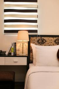 1 dormitorio con 1 cama y escritorio con lámpara en Serenity Diamond Hotel, en Hanói