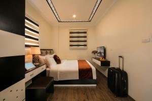 a hotel room with a bed and a suitcase at Serenity Diamond Hotel in Hanoi
