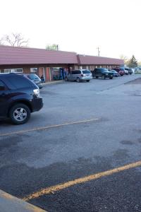 a parking lot with cars parked in front of a building at Lazy U Motel in Rapid City