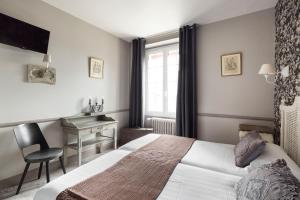 A bed or beds in a room at Logis Maison Vauban - Hotel St Malo