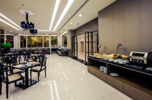 un restaurante con mesas y sillas y un buffet en Mandarin Hotel Managed by Centre Point en Bangkok