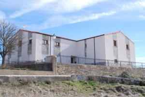 un bâtiment blanc au-dessus d'un mur de briques dans l'établissement Albergue Turístico Tierras Altas, à Fuentes de Magaña