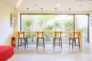 a dining room with a table and stools at Red Planet Manila Malate Mabini in Manila