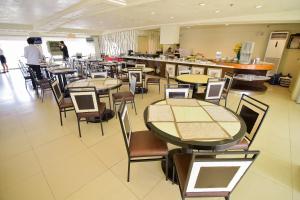 a restaurant with tables and chairs and a counter at Hotel Tavern Surigao in Surigao