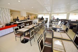 Hotel Tavern Surigao في مدينة سوريجاو: مطعم بطاولات وكراسي وكاونتر