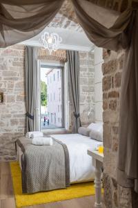 um quarto com uma cama e uma janela em Zara Palace - design rooms em Zadar