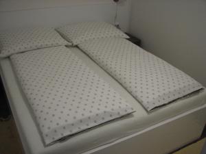 a white bed with polka dot pillows on it at Apartment Vito in Plitvička Jezera