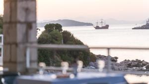 a boat in the water with a ship in the distance at Hotel Vis in Dubrovnik