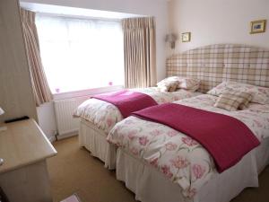 um quarto com 2 camas e uma janela em Honey Lodge em Broadstone