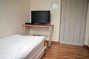 1 dormitorio con 1 cama y TV en una mesa en YaKorea Hostel Gangnam en Seúl