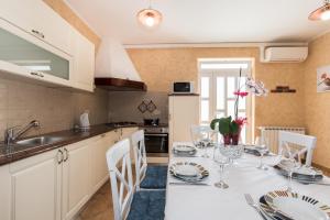a kitchen with a table with plates and wine glasses at Apartman EN in Mošćenička Draga +66 photos