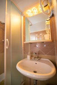 W łazience znajduje się umywalka i lustro. w obiekcie Bed&Breakfast Saturn w mieście Veli Lošinj