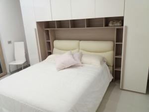 una camera con un letto bianco e una sedia di Villa Sabaudia a Sabaudia