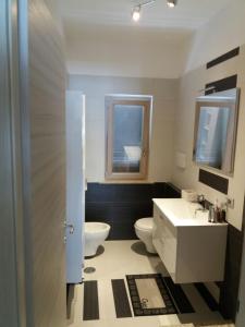 een badkamer met een wastafel, een toilet en een raam bij Villa Sabaudia in Sabaudia