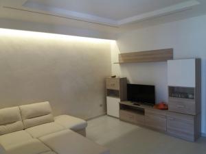 a living room with a couch and a flat screen tv at Villa Sabaudia in Sabaudia
