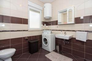 ein Badezimmer mit Waschmaschine und Waschbecken in der Unterkunft Apartment Jusepe in Trogir + 37 Fotos