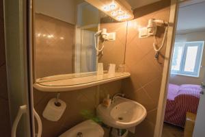 ein kleines Bad mit einem Waschbecken und einem WC in der Unterkunft Bed&Breakfast Saturn in Veli Lošinj