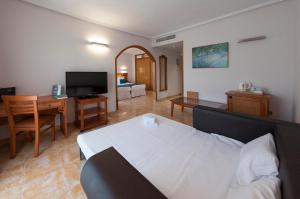 a room with a bed and a desk and a television at Hotel La Laguna Spa & Golf in Torrevieja
