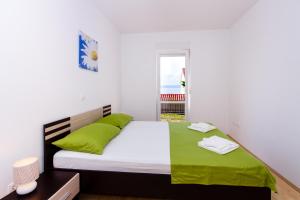 ein Schlafzimmer mit einem großen Bett mit grünen Kissen in der Unterkunft Apartment Jusepe in Trogir