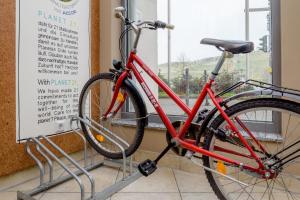 uma bicicleta vermelha estacionada ao lado de uma janela em ibis Hotel Würzburg City em Wurtzburgo