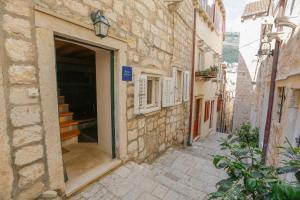 an alley with a door and stairs in a building at Apartment Sorta in Dubrovnik