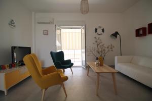 a living room with a couch and two chairs and a table at Colori a mare in Villaggio Azzurro
