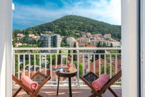 een balkon met stoelen en uitzicht op de stad bij Apartment Marilyn in Dubrovnik