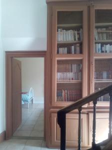een bibliotheek met een houten boekenplank met boeken bij La tour du Roy in Villeneuve-sur-Allier