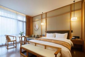 a hotel room with a large bed and a chair at 西安汉乐府酒店 - Xi'an Paradise Hotel of Han Dynasty in Xi'an +73 photos
