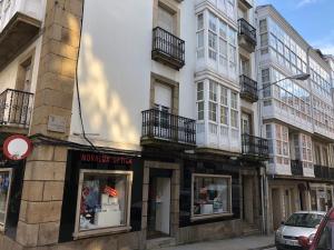 une rangée de bâtiments dans une rue de la ville dans l'établissement TuristiQA - Piso C Arenal 20 2º VUT-CO-01678, à Ferrol