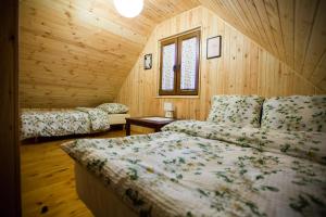 - une chambre avec 2 lits dans une cabane en bois dans l'établissement Domki Letniskowe Roztocze, à Zwierzyniec