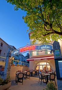 un groupe de tables et de chaises devant un restaurant dans l'établissement Le Signoret, à Sault