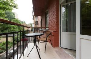 einen Balkon mit einem Tisch und Stühlen darauf in der Unterkunft Апартаменты на Бассейной in Kiew