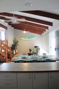 ein Wohnzimmer mit einem Tisch mit Stühlen und einem Pool in der Unterkunft Mignon Cottage 9 Noongah Terrace in Crescent Head