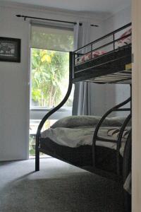 
a bunk bed in a room with a window at Mignon Cottage 9 Noongah Terrace in Crescent Head
