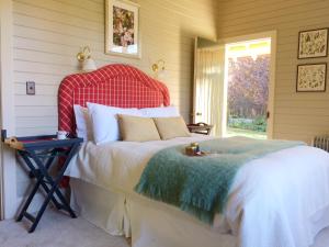 a bedroom with a bed with a red and white blanket at Leader Valley Cottage - A Tranquil Retreat For Two in Mendip Hills