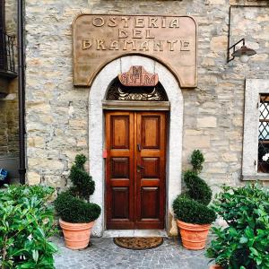 a wooden door in a stone building with potted plants at Albergo del Bramante in Roccaverano