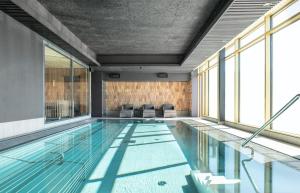 a swimming pool in a building with windows at Quality Hotel The Box in Linköping