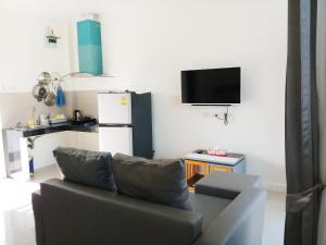 a living room with a couch and a refrigerator at Long N Joy Samui in Chaweng