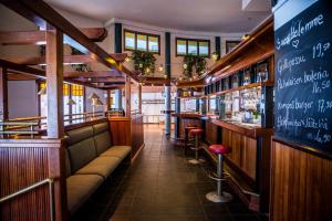 a restaurant with a bar with benches and tables at Hotelli Kampeli in Veteli
