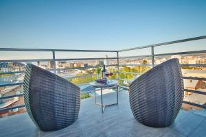 two chairs on a balcony with a view of the city at Hotel Orion Tbilisi in Tbilisi City