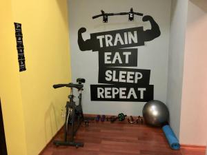 a room with a bike and a sign that reads train eat sleep repeat at SAHIL Hostel & Hotel in Baku