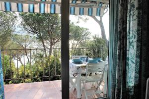 Una mesa blanca y sillas en un balcón con vista. en Scaglieri Mare by ArgonautiVacanze, en Portoferraio