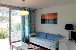 Una sala de estar con un sofá azul y una ventana. en Scaglieri Mare by ArgonautiVacanze, en Portoferraio
