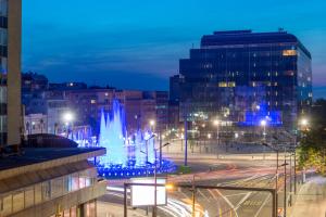 a view of a city at night with a fountain at Apartments Top Central 3 in Belgrade