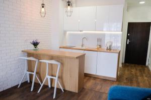 a kitchen with a counter with two stools and a sink at Apartment & Room MARINA BORKI - Apartamenty ZEFIR in Augustów
