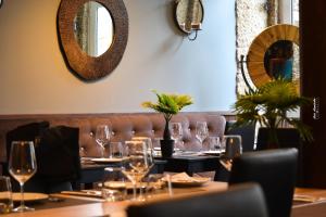 uma sala de jantar com uma mesa com copos de vinho em Pao 100 Pressa na Covilh