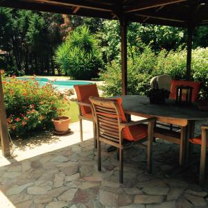 a wooden table and chairs on a stone patio at Chia - Casa Margherita in Chia
